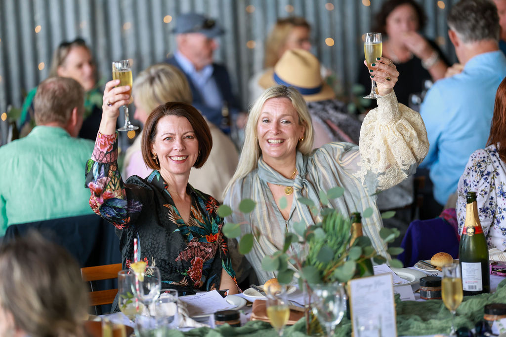 Guests raising their glasses together at a long table