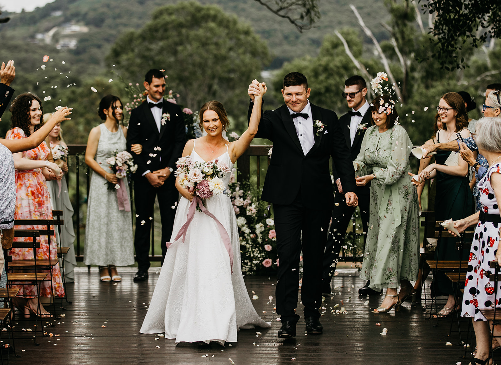 A newly married couple walking back down the aisle through their guests