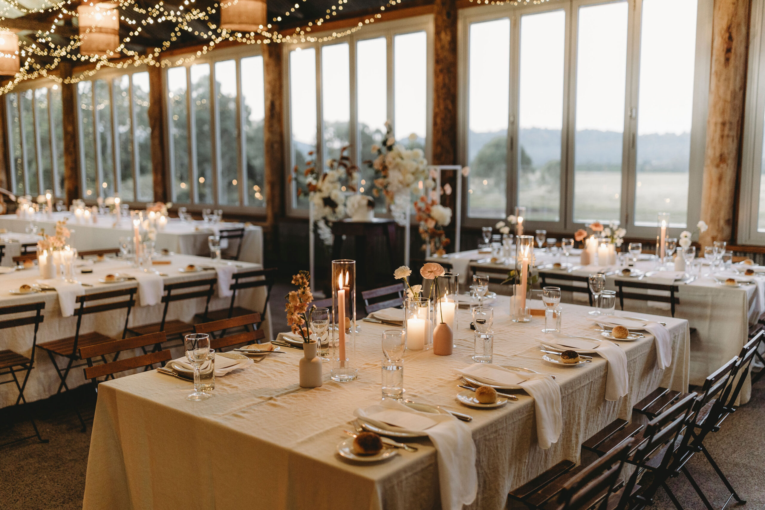 A place setting with candles and terracotta florals on white linen