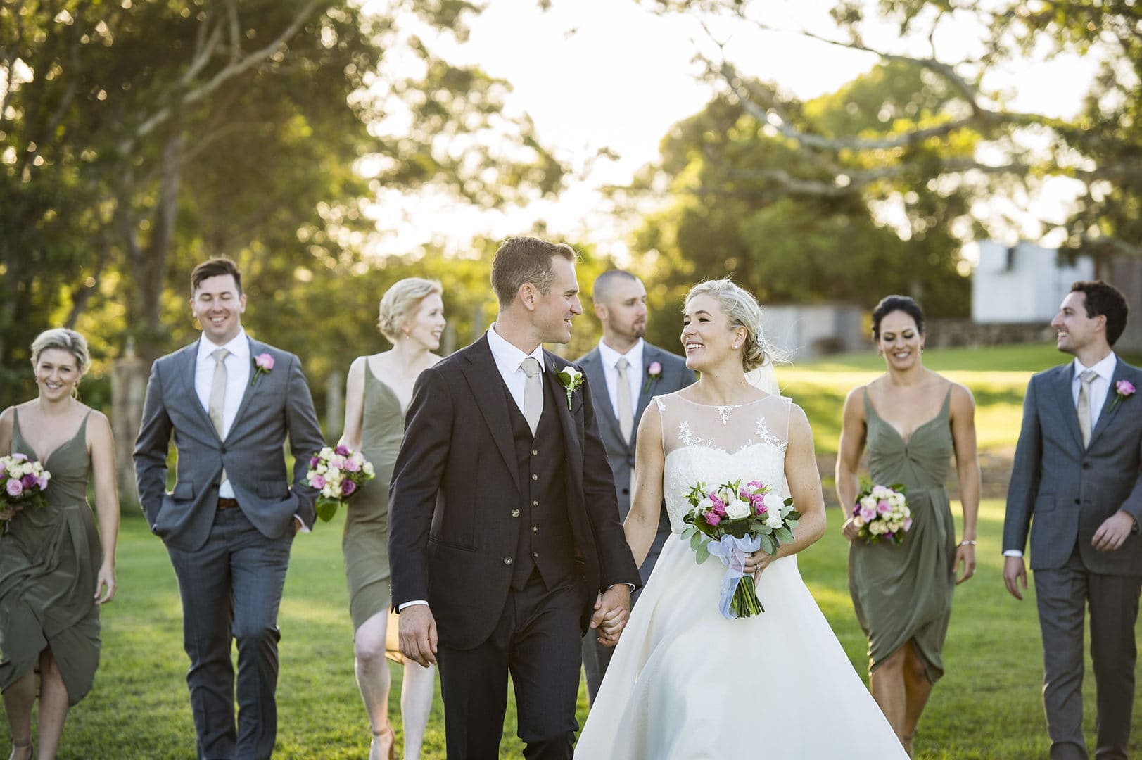 The wedding party walking through the paddock in golden hour light
